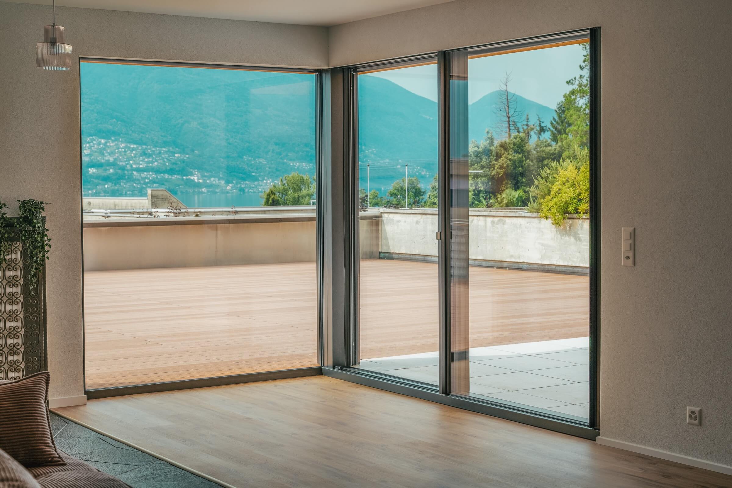Interno con vetrata minimale e vista sul lago